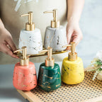 White ceramic hand soap dispenser with marble design and plastic pump on countertop for bathroom and kitchen decor